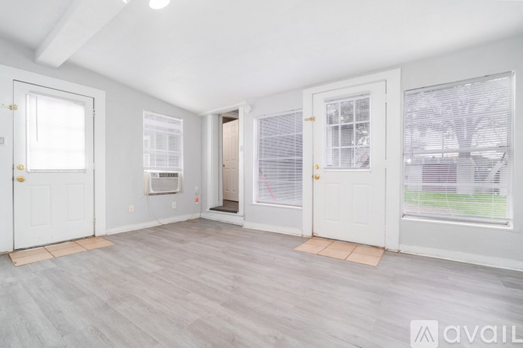 A room with white doors and a grey floor.