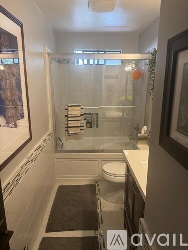 A bathroom with a toilet, sink and shower.