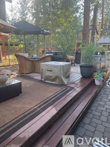 A patio with a table and chairs covered with a white cloth.
