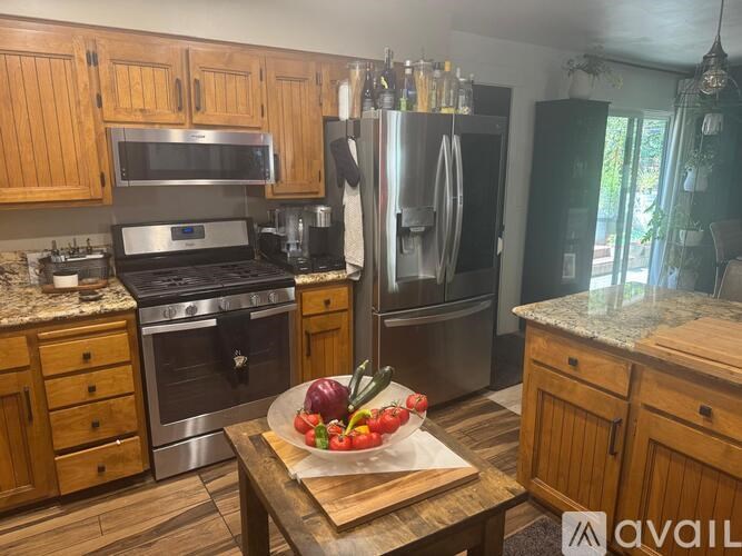 A kitchen with wooden cabinets and a granite countertop.