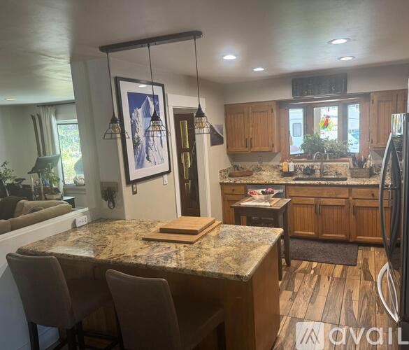 A kitchen with a granite countertop and wooden cabinets.