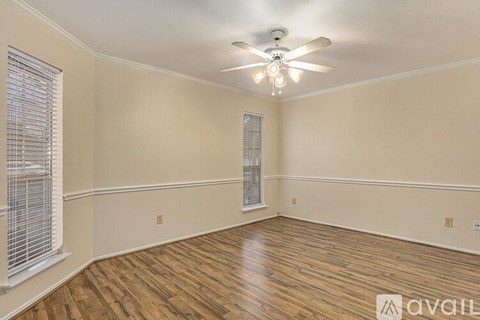 A room with wooden floors and a ceiling fan.