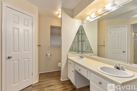 A bathroom with a white door, a white sink, and a mirror.