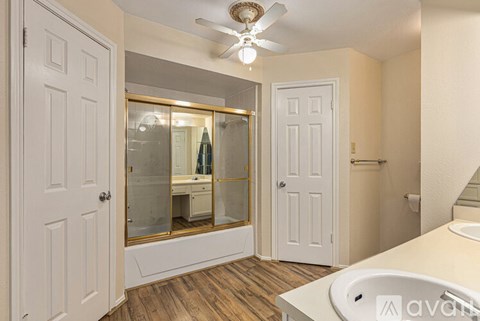 A bathroom with a white tub and a white door.