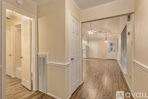 A hallway with wood floors and white walls.