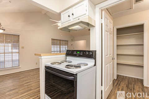 A kitchen with a stove top oven and a range hood above it.