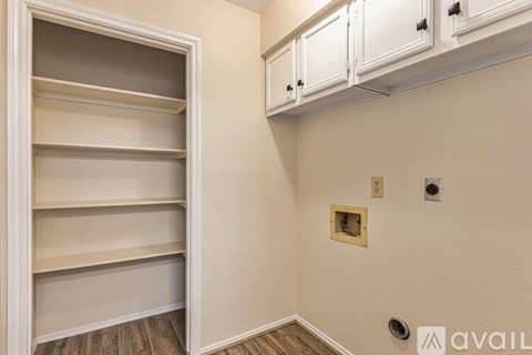 A room with a white cabinet and a white shelving unit.