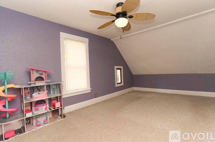 A room with a ceiling fan and a window.