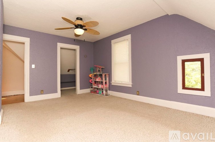 A room with purple walls and a ceiling fan.