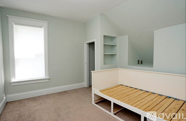 A room with a window, a bed, and a closet.