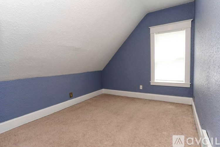 A room with a window and a carpeted floor.