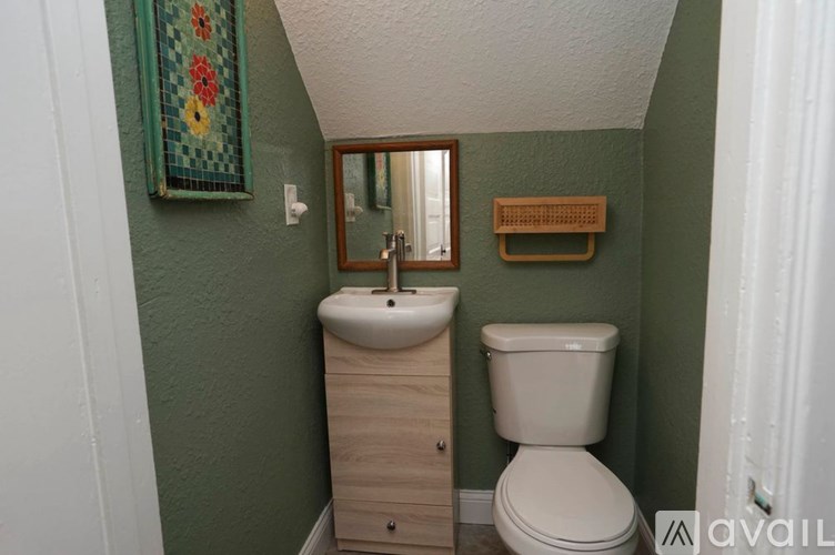 A bathroom with green walls and a white toilet.