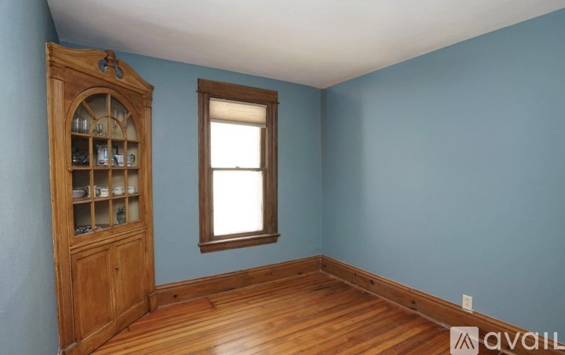 A room with a wooden cabinet and a window.