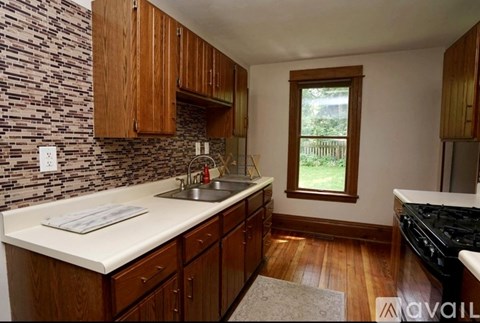 A kitchen with wooden cabinets and a stone backsplash.