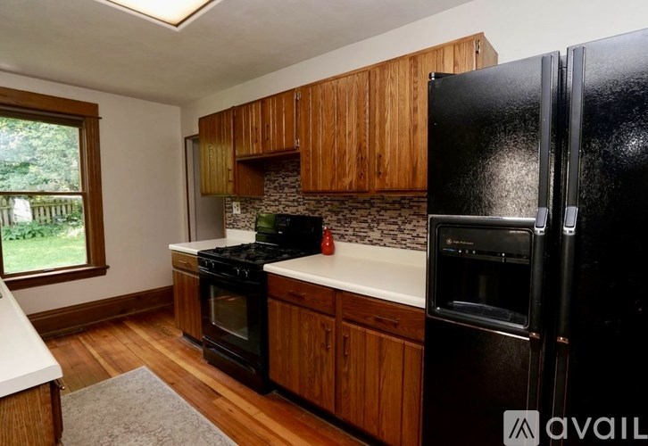 A kitchen with black appliances and wooden cabinets.