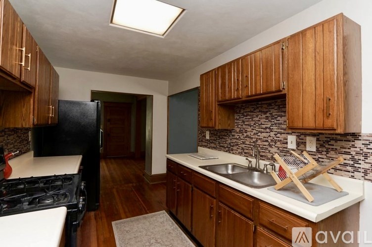 A kitchen with wooden cabinets and a black stove top oven.