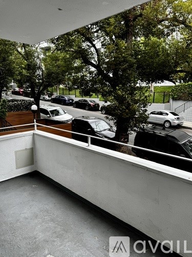 A parking lot with cars and trees visible through a window.