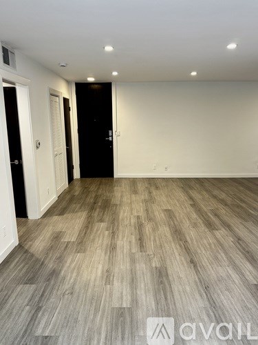 A room with wooden flooring and white walls.