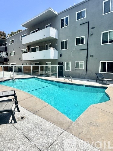 A swimming pool in front of a multi-story apartment building.