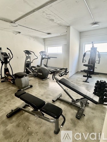 A gym with a variety of equipment including treadmills, weights, and exercise machines.