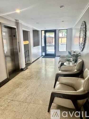 A hallway with chairs and a wall hanging.