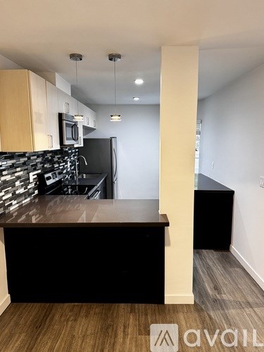 A kitchen with a black fridge and a wooden counter.