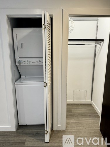 A white fridge is in a cabinet in a room.