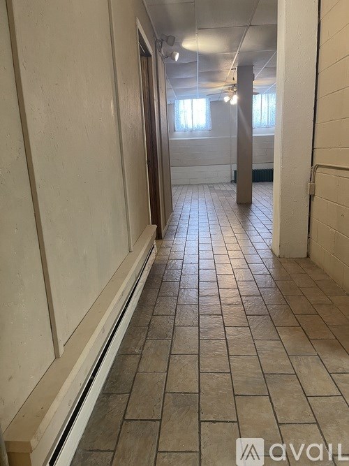 A long hallway with tiled floors and white walls.