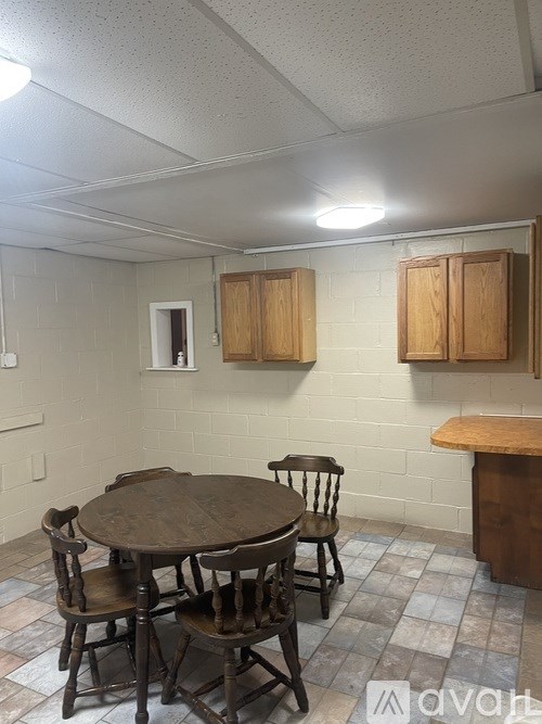 A dining room with a table and chairs.