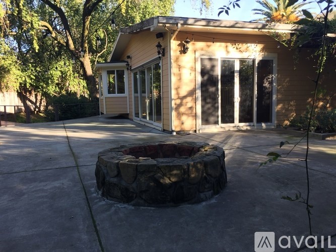 A house with a stone fire pit in the driveway.