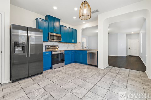 A kitchen with blue cabinets and a marble floor.