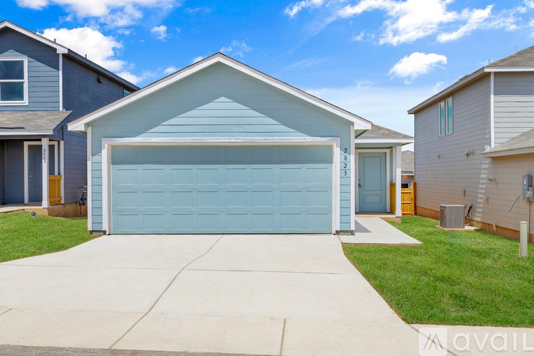 A blue garage door in front of a house.