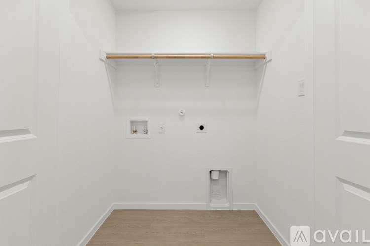 A white room with a shelf and a small picture on the wall.