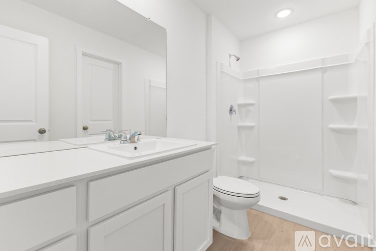 A white bathroom with a toilet, sink, and bathtub.