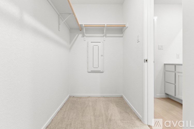A white room with a door and a carpet on the floor.
