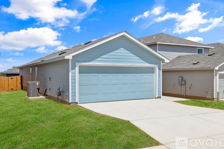 A house with a blue garage door and a driveway leading to it.