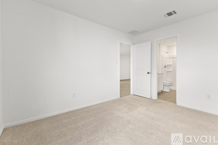 A room with a carpeted floor and a door leading to another room.
