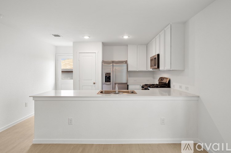 A kitchen with white cabinets and a white island.