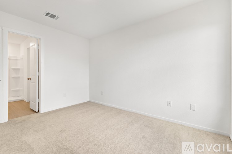 A room with a carpeted floor and a doorway leading to another room.