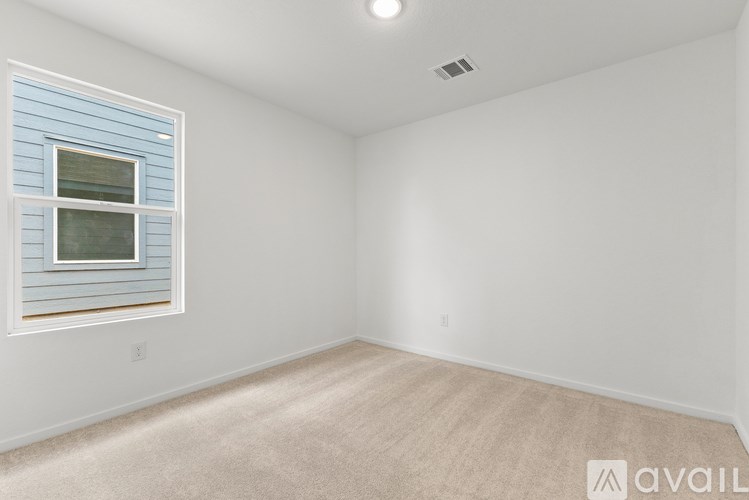 A room with a window and carpeted floor.