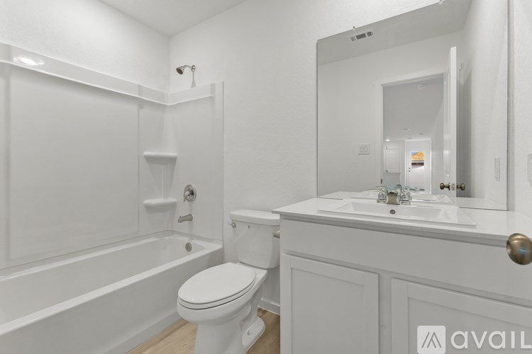 A white bathroom with a toilet, sink, and bathtub.