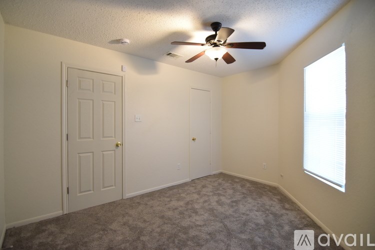 A room with a ceiling fan and two doors.