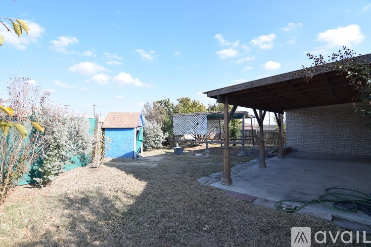 A backyard with a shed and a fence.