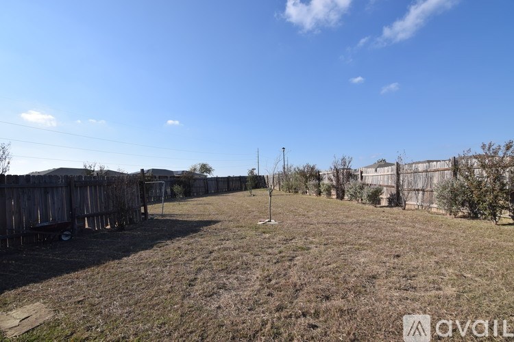 A backyard with a fence and a clear blue sky.