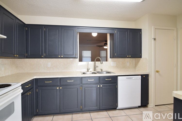 A kitchen with dark cabinets and a white dishwasher.