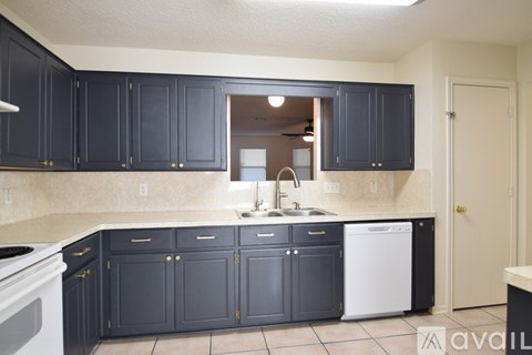 A kitchen with dark cabinets and a white dishwasher.