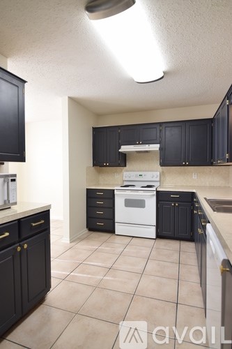 A kitchen with black cabinets and a white oven.