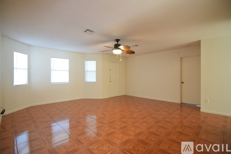 A room with a ceiling fan and tile flooring.
