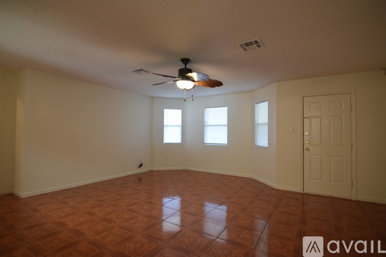 A room with a ceiling fan and tiled floor.