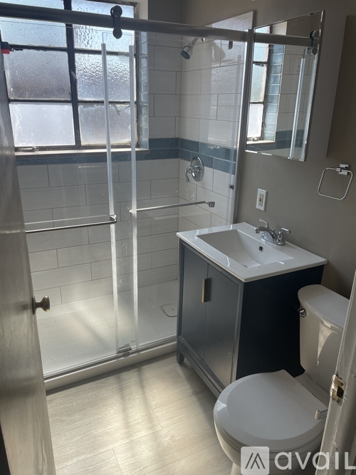 A bathroom with a toilet, sink, and shower.